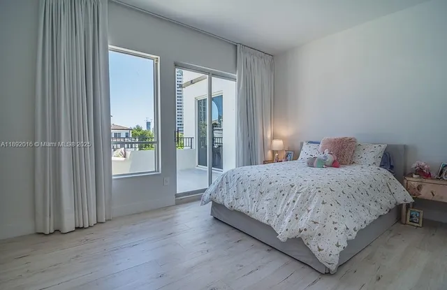 a bedroom with two beds and a large window