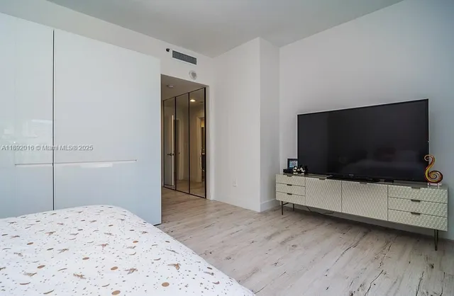 a bedroom with a bed and a flat screen tv