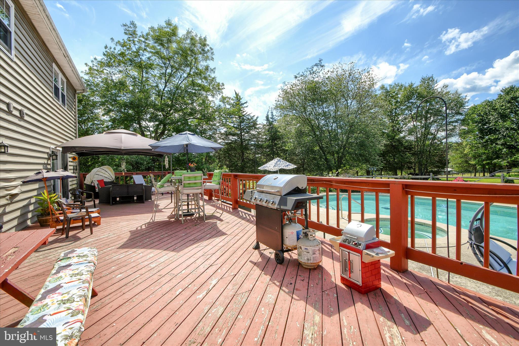 1010 Sweetbriar Road Perkasie, PA 18944 - Photo 45 of 59 a view of a patio with table and chairs under an umbrella with wooden floor