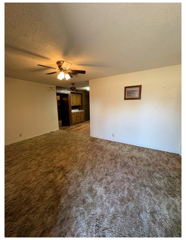 Large living room with ceiling fan. 