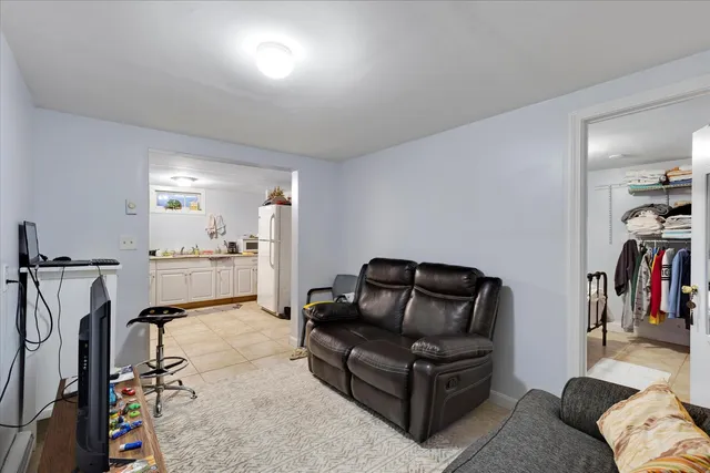a living room with furniture and a gym machine with wooden floor