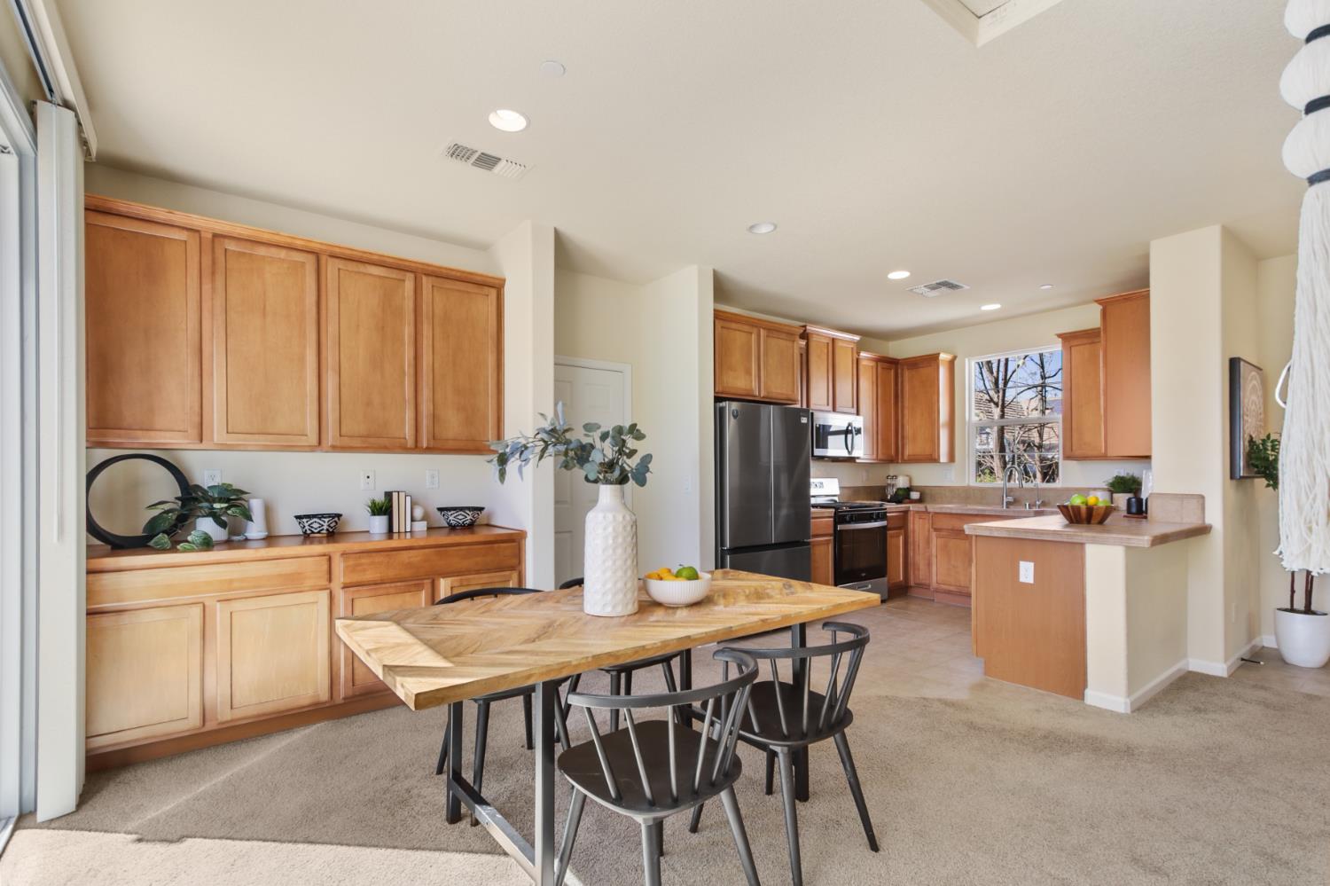 2128 Ragen Place Woodland, CA 95776 - Photo 12 of 40 a kitchen with stainless steel appliances kitchen island granite countertop a dining table and chairs