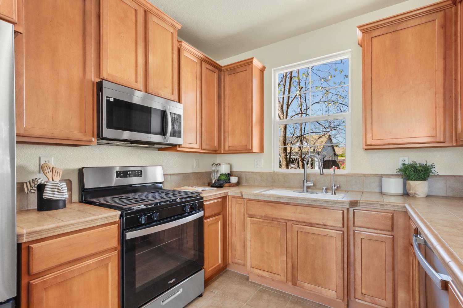 2128 Ragen Place Woodland, CA 95776 - Photo 16 of 40 a kitchen with stainless steel appliances granite countertop white cabinets a stove a sink and dishwasher