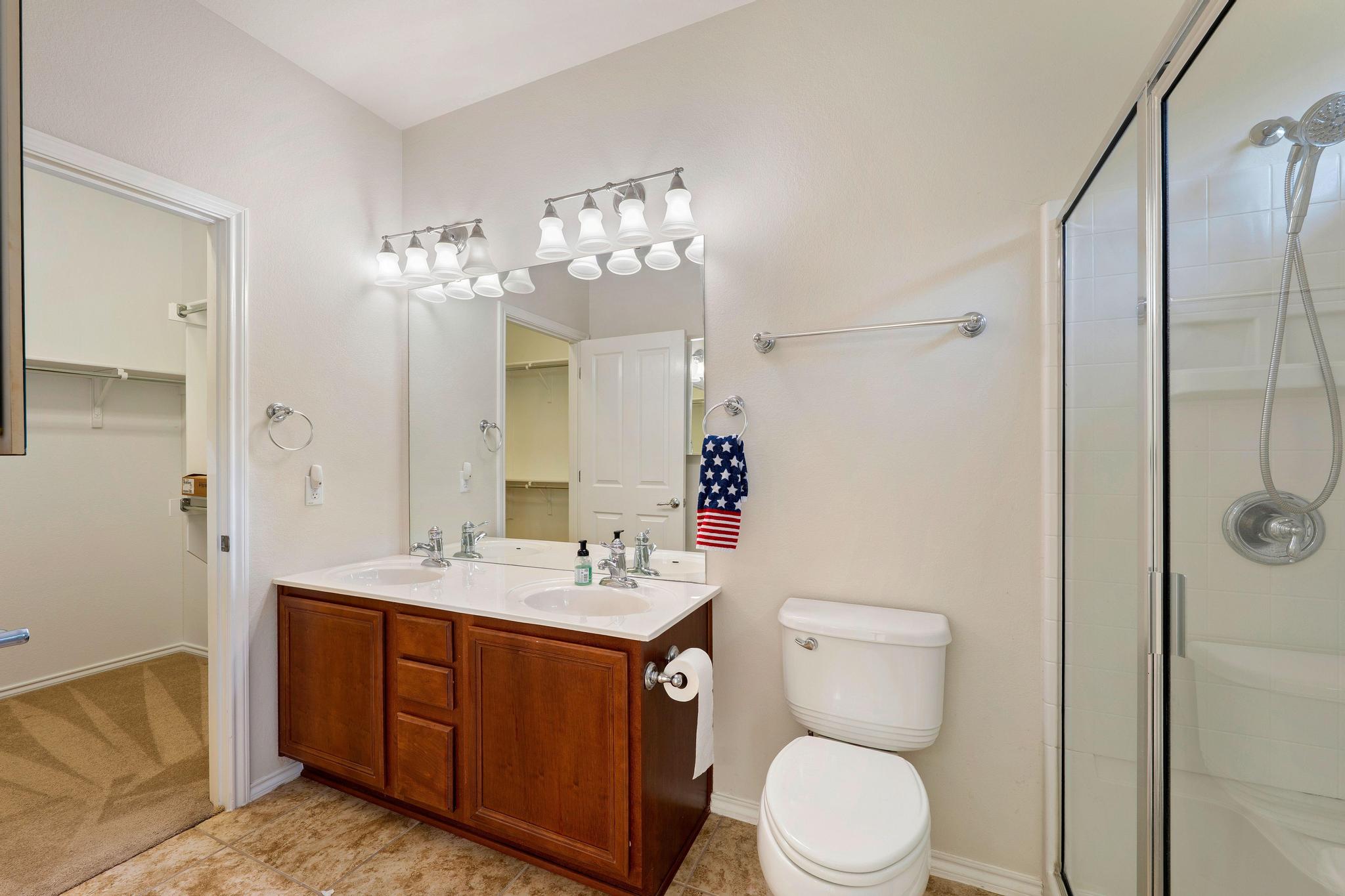520 Mill Pond Path Georgetown, TX 78633 - Photo 27 of 38 Double vanity sinks and a glass-enclosed shower create a practical bathroom retreat.