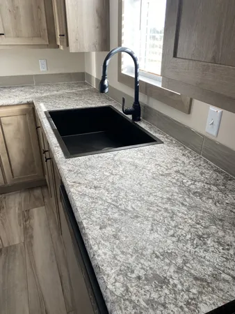 a kitchen with granite countertop a sink and a stove