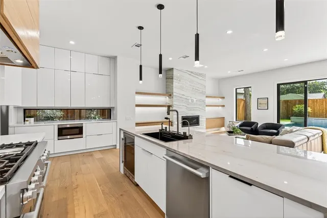 a kitchen with stainless steel appliances granite countertop a stove a sink and white cabinets