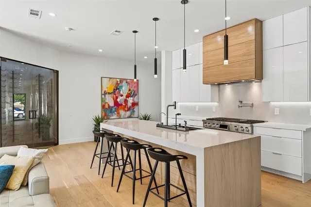 a kitchen with stainless steel appliances granite countertop white cabinets and wooden floor