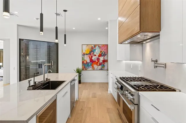 a kitchen with stainless steel appliances granite countertop a stove a sink a refrigerator and a dining table