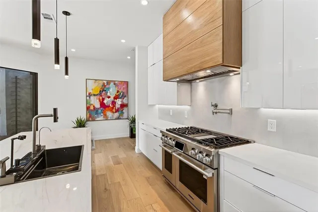 a kitchen with stainless steel appliances a sink a stove and a refrigerator