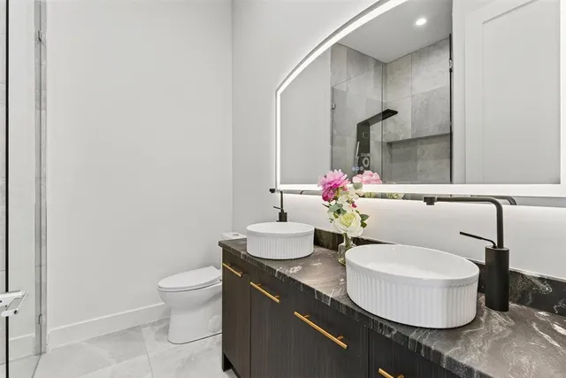 a bathroom with a granite countertop sink mirror and a bathtub