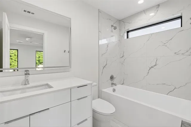a bathroom with a sink toilet vanity and bathtub