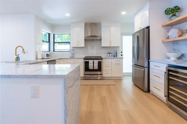 a kitchen with stainless steel appliances granite countertop a refrigerator sink and stove