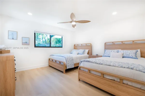 a bedroom with two beds and painting on the wall