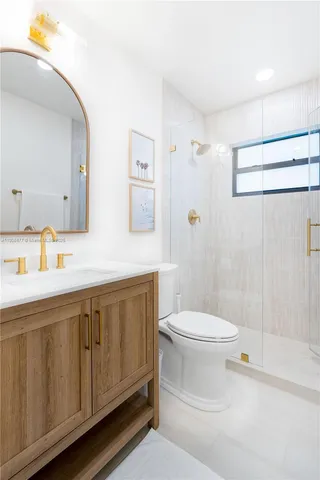 a bathroom with a double vanity sink toilet and shower
