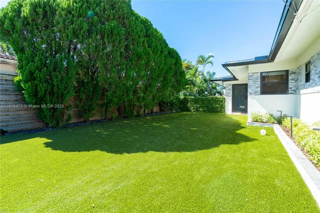 a view of a house with a yard porch and a tree
