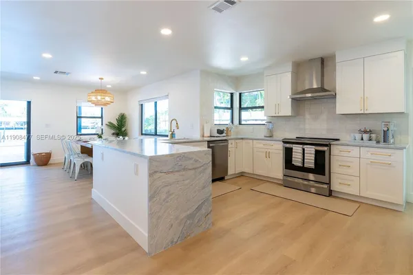 a large kitchen with stainless steel appliances granite countertop a stove and a sink