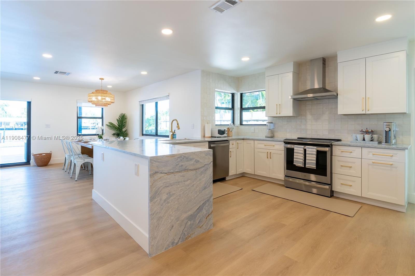 309 South Riverside Drive Pompano Beach, FL 33062 - Photo 10 of 23 a large kitchen with stainless steel appliances granite countertop a stove and a sink