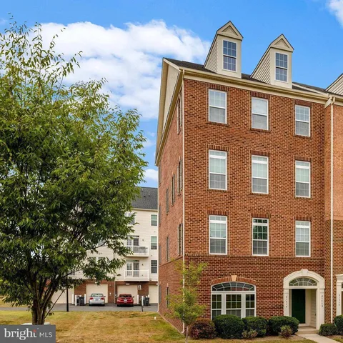 a front view of a building with lot of trees