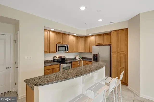 a kitchen with stainless steel appliances granite countertop a refrigerator stove microwave and sink