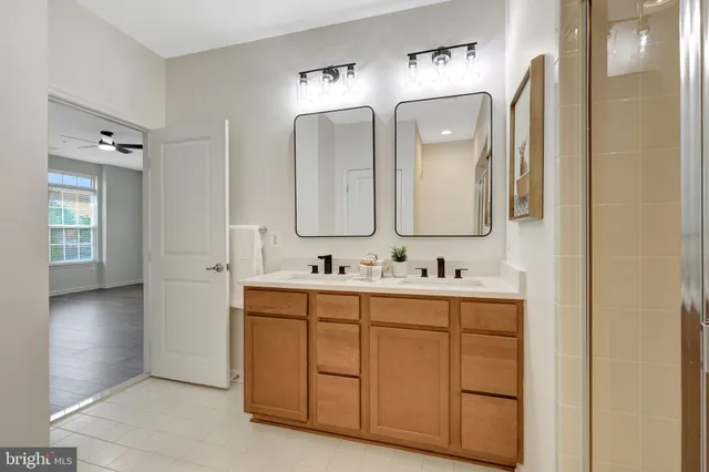 a bathroom with a double vanity sink and mirror with shower