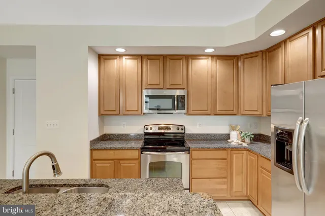 a kitchen with a refrigerator and a stove top oven