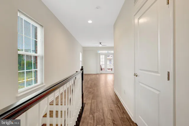 a view of a hallway with wooden floor and staircase