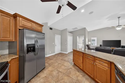 a kitchen with granite countertop stainless steel appliances a sink stove top oven and cabinets