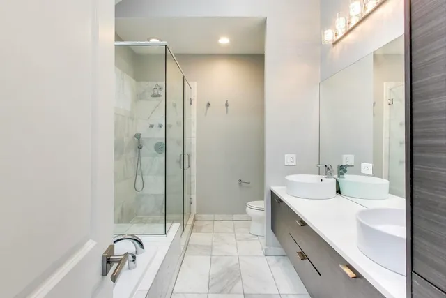 a bathroom with a double vanity sink and mirror with shower