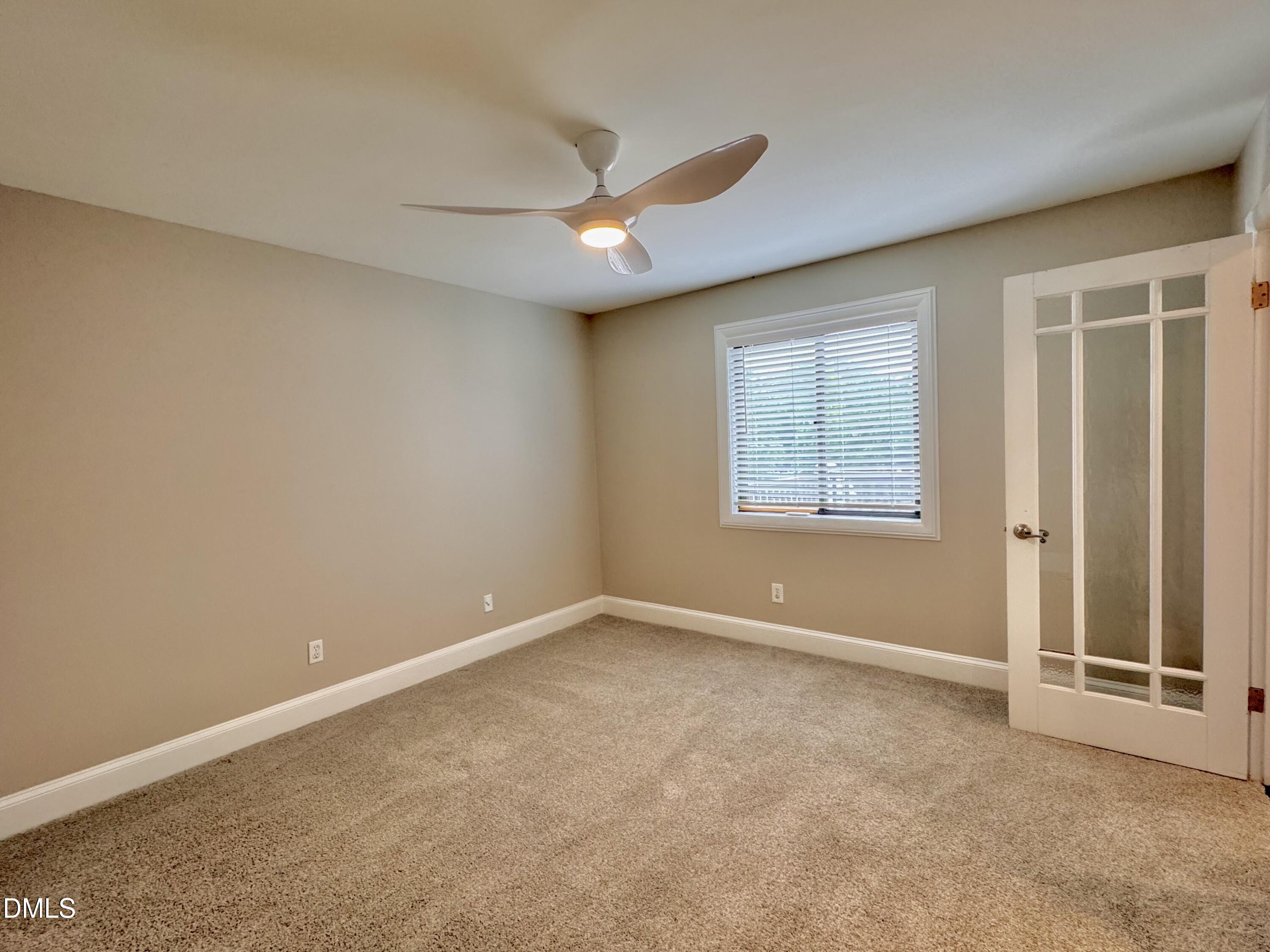 2204 Stafford Avenue, Unit 202 Raleigh, NC 27607 - Photo 12 of 15 an empty room with ceiling fan and windows