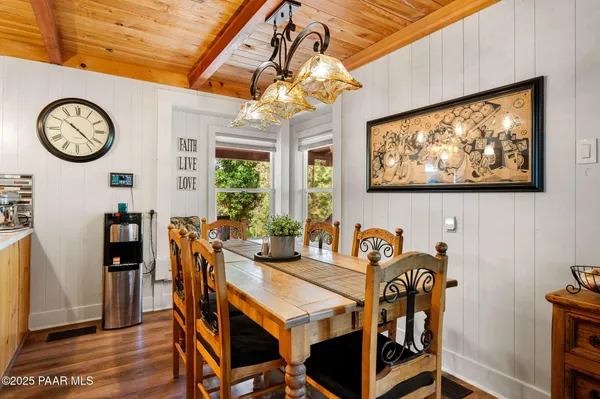 a view of a dining room with furniture a rug and wooden floor