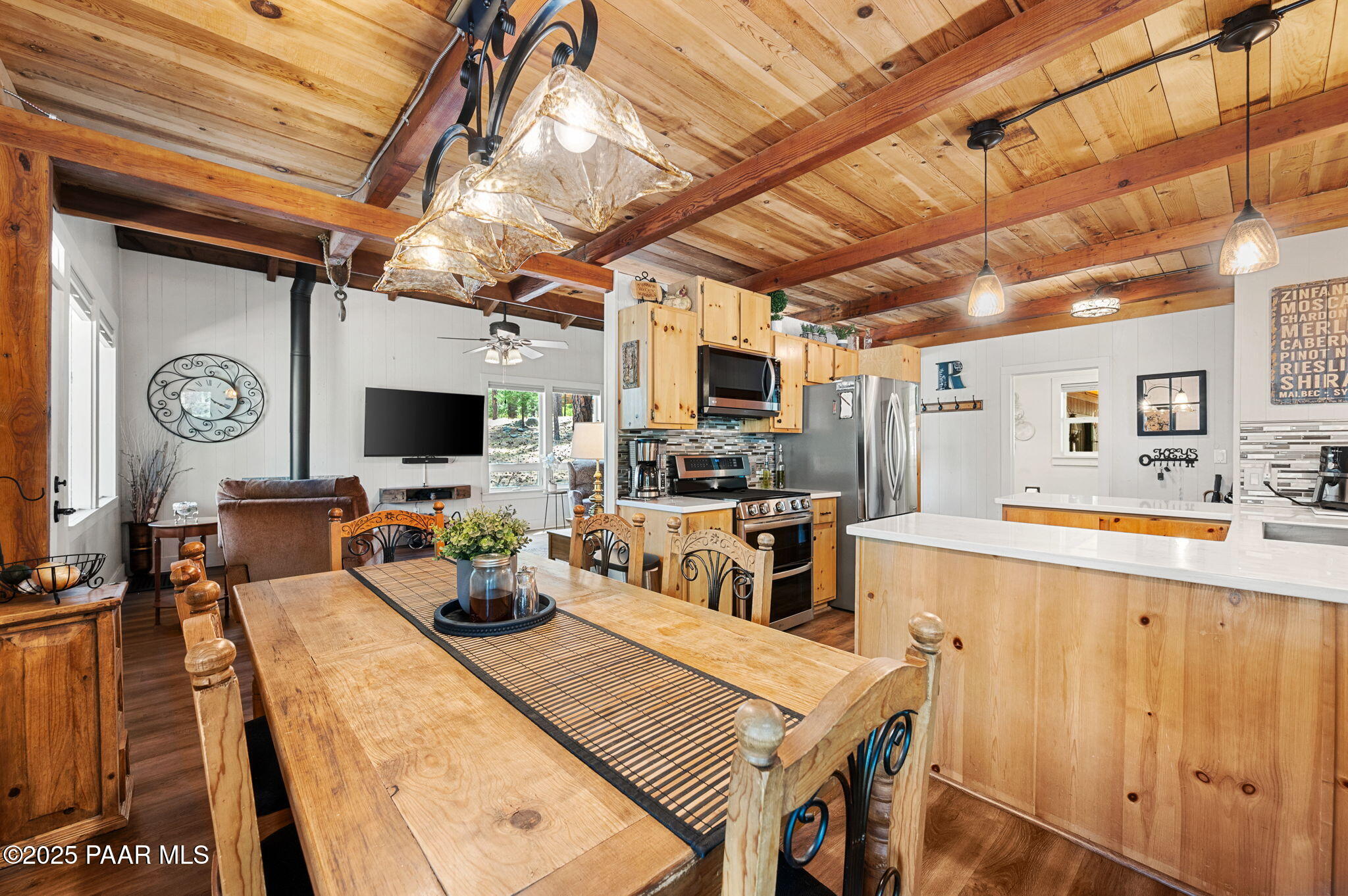 6231 South Champion Way Road Prescott, AZ 86303 - Photo 13 of 43 a kitchen with stainless steel appliances granite countertop a sink a stove top oven a chimney cabinets and a dining table