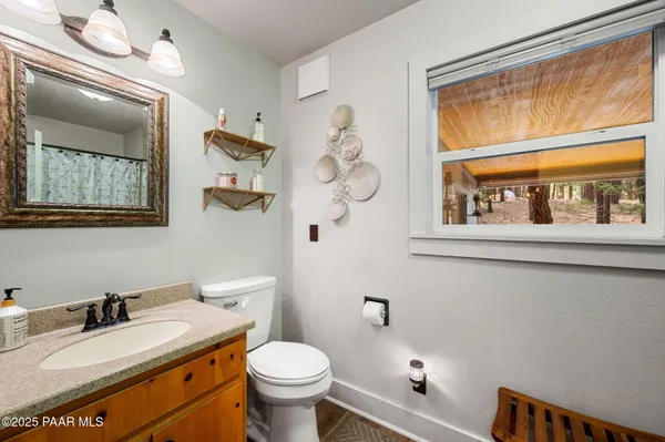 a bathroom with a granite countertop sink mirror vanity and toilet