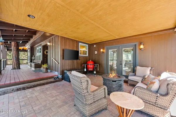 a living room with furniture a flat screen tv and a table