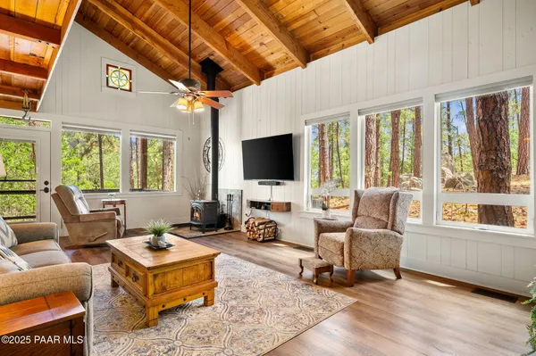 a living room with furniture a flat screen tv and a large window
