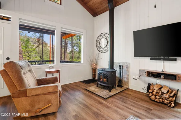 a living room with furniture a flat screen tv and a large window