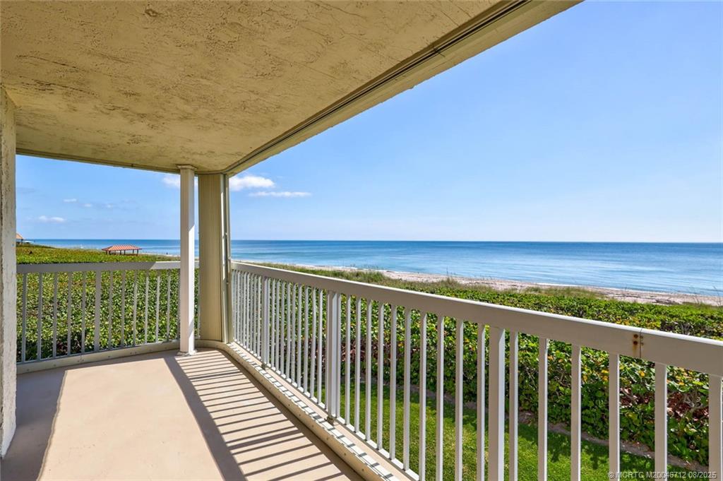 a view of a balcony with floor to ceiling windows with wooden floor