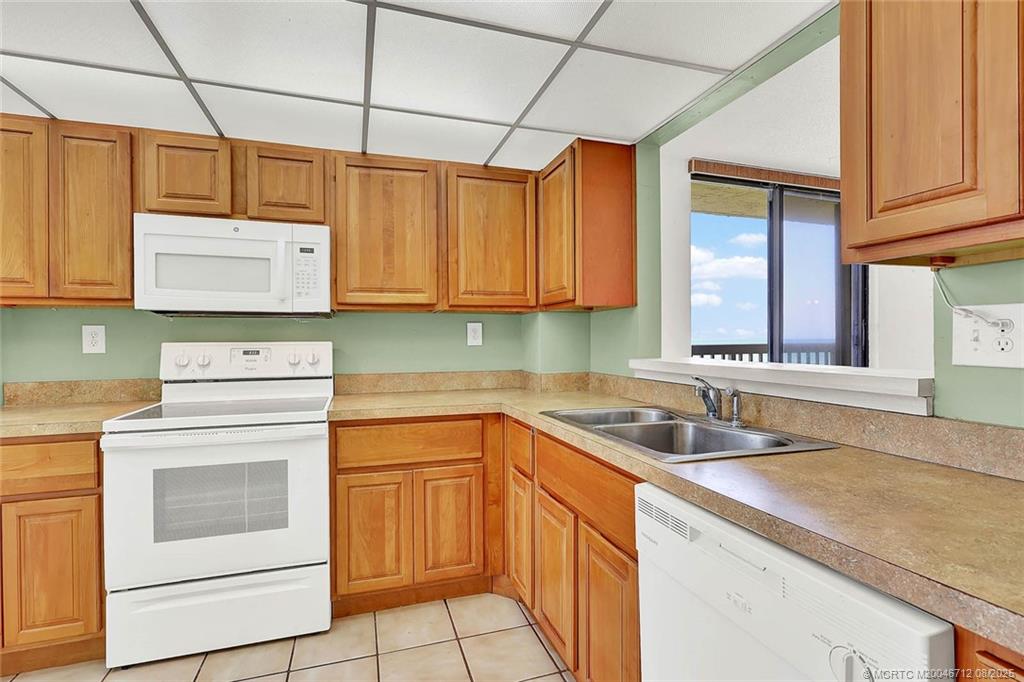 10600 South Ocean Drive, Unit 201 Jensen Beach, FL 34957 - Photo 11 of 40 a kitchen with cabinets appliances a sink and a counter top space