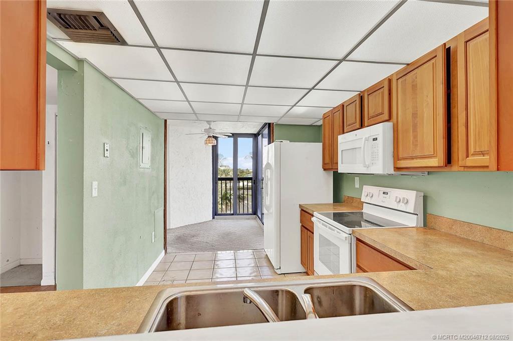 10600 South Ocean Drive, Unit 201 Jensen Beach, FL 34957 - Photo 16 of 40 a kitchen with stainless steel appliances granite countertop a sink a stove and a refrigerator