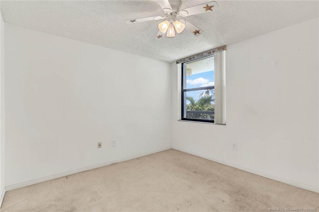 10600 South Ocean Drive, Unit 201 Jensen Beach, FL 34957 - Photo 29 of 40 an empty room with a window and a fan