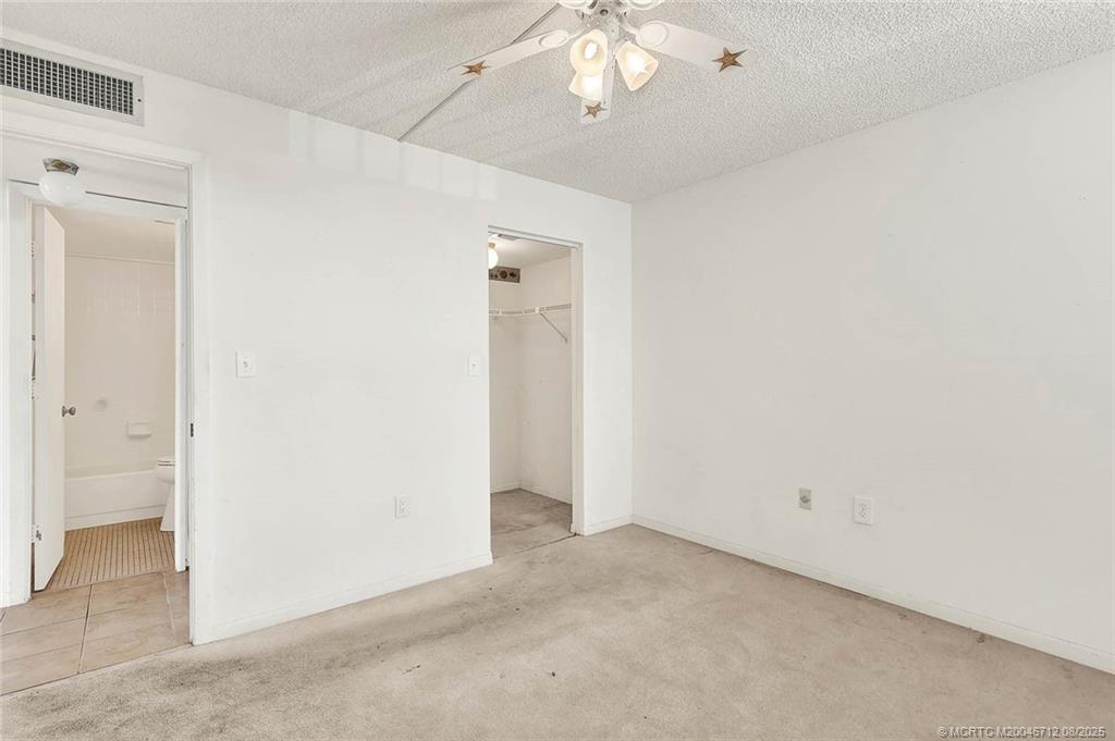 10600 South Ocean Drive, Unit 201 Jensen Beach, FL 34957 - Photo 32 of 40 an empty room with a chandelier fan