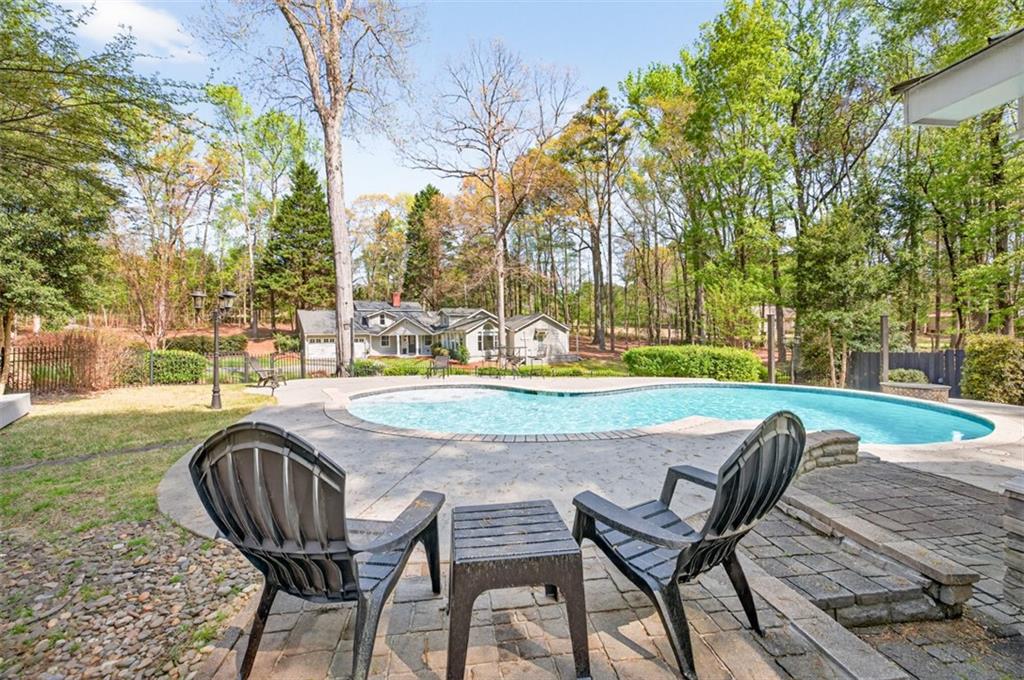 627 Rock Springs Road Lawrenceville, GA 30043 - Photo 56 of 85 a view of a swimming pool with lawn chairs and a yard