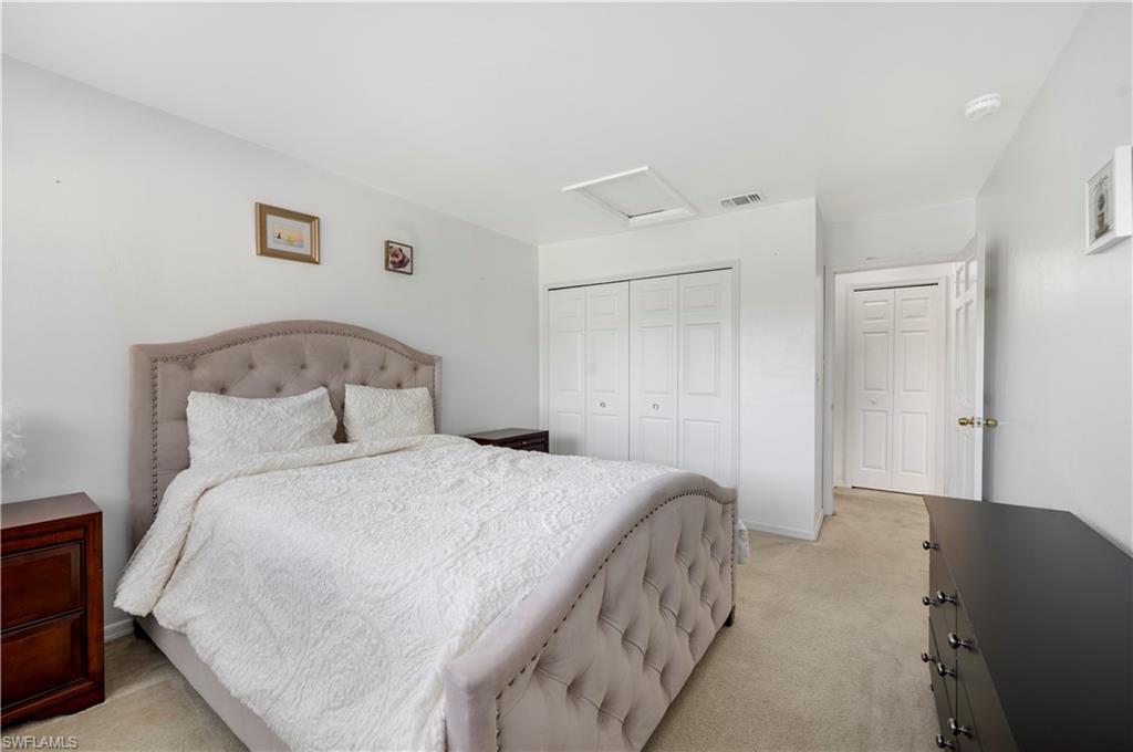 908 Augusta Boulevard, Unit A907 Naples, FL 34113 - Photo 15 of 20 a bedroom with a bed and a lamp