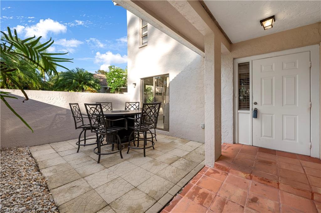 908 Augusta Boulevard, Unit A907 Naples, FL 34113 - Photo 19 of 20 a view of a patio with table and chairs and potted plants