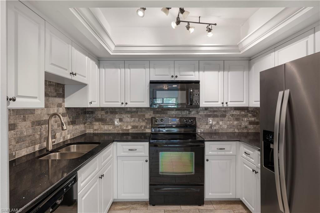 908 Augusta Boulevard, Unit A907 Naples, FL 34113 - Photo 9 of 20 a kitchen with a sink a stove and refrigerator