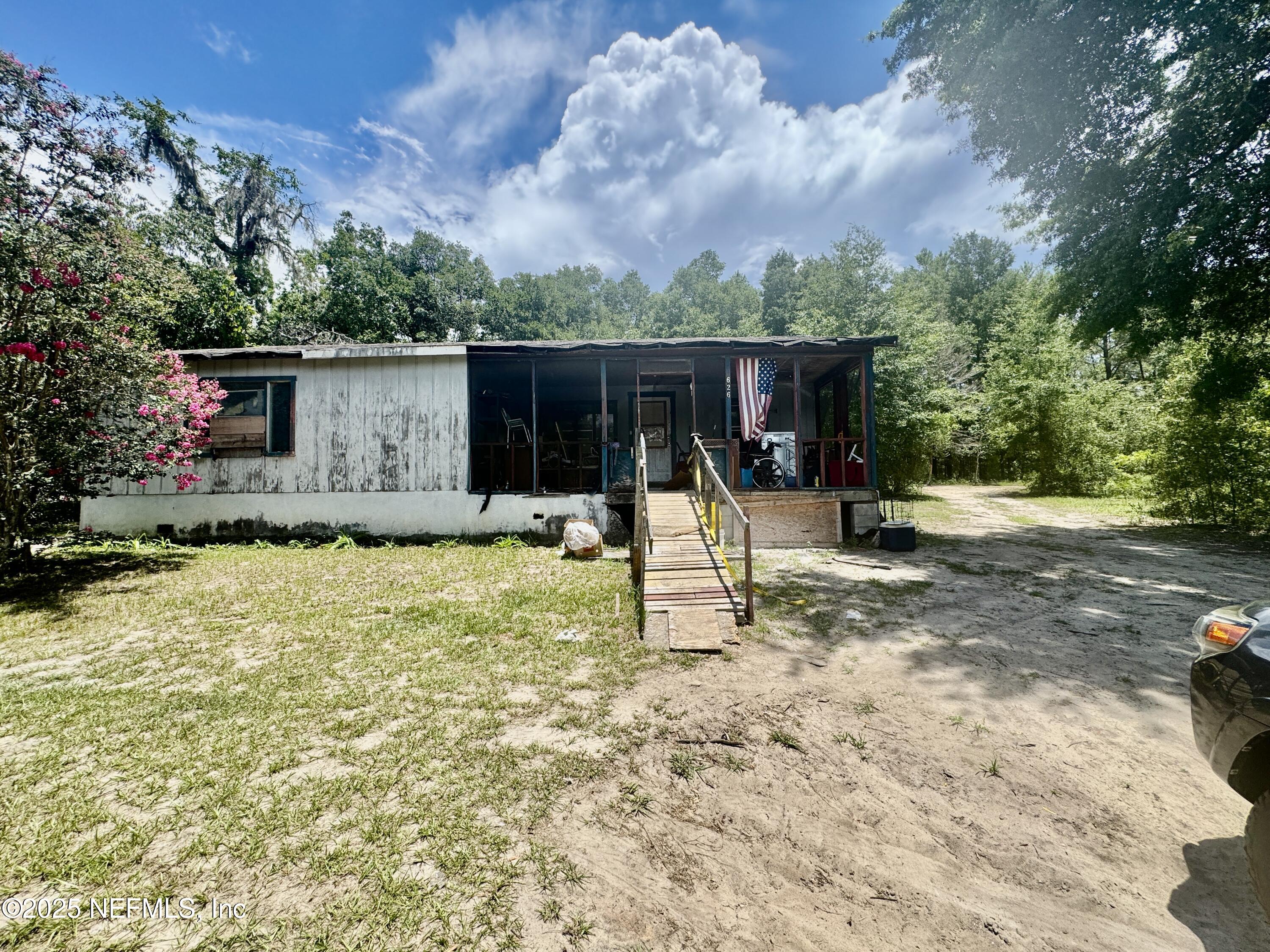 a view of a backyard with a slide trees and wooden fence