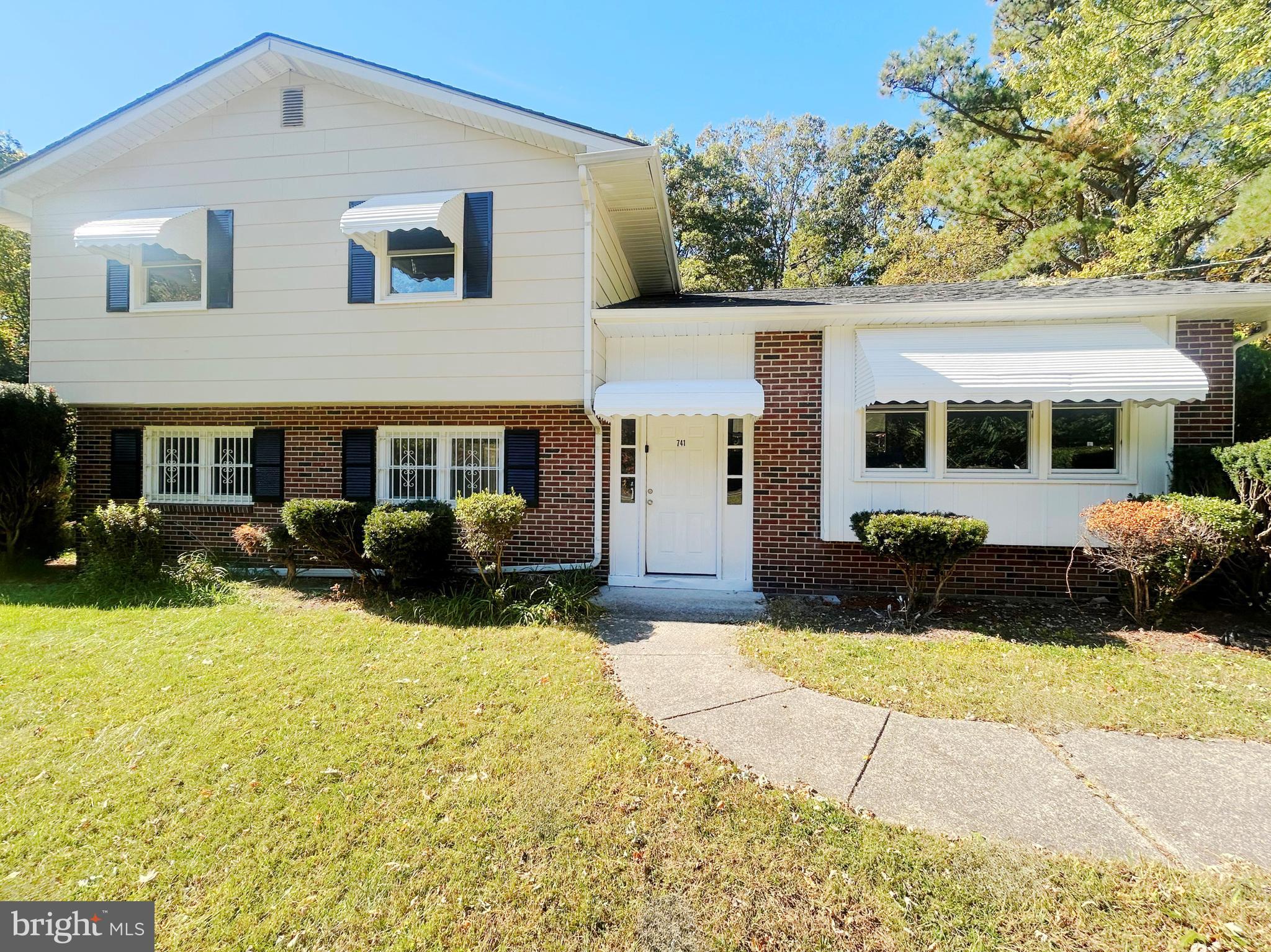 a view of a white house with a yard and plants