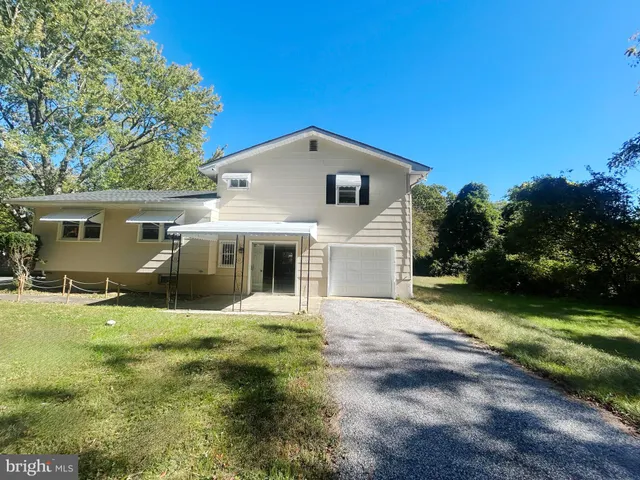 a front view of a house with yard and green space
