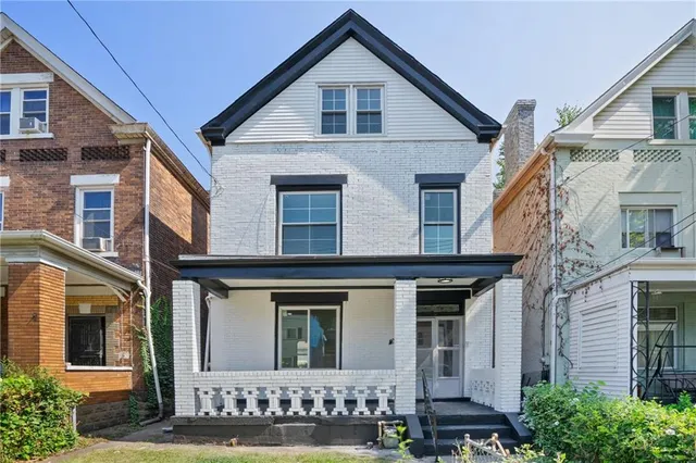 a view of a brick house with large windows