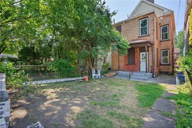 a view of a house with a yard and potted plants