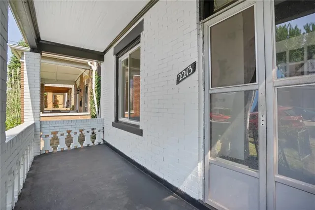 a view of a brick house with large windows and a table and chairs